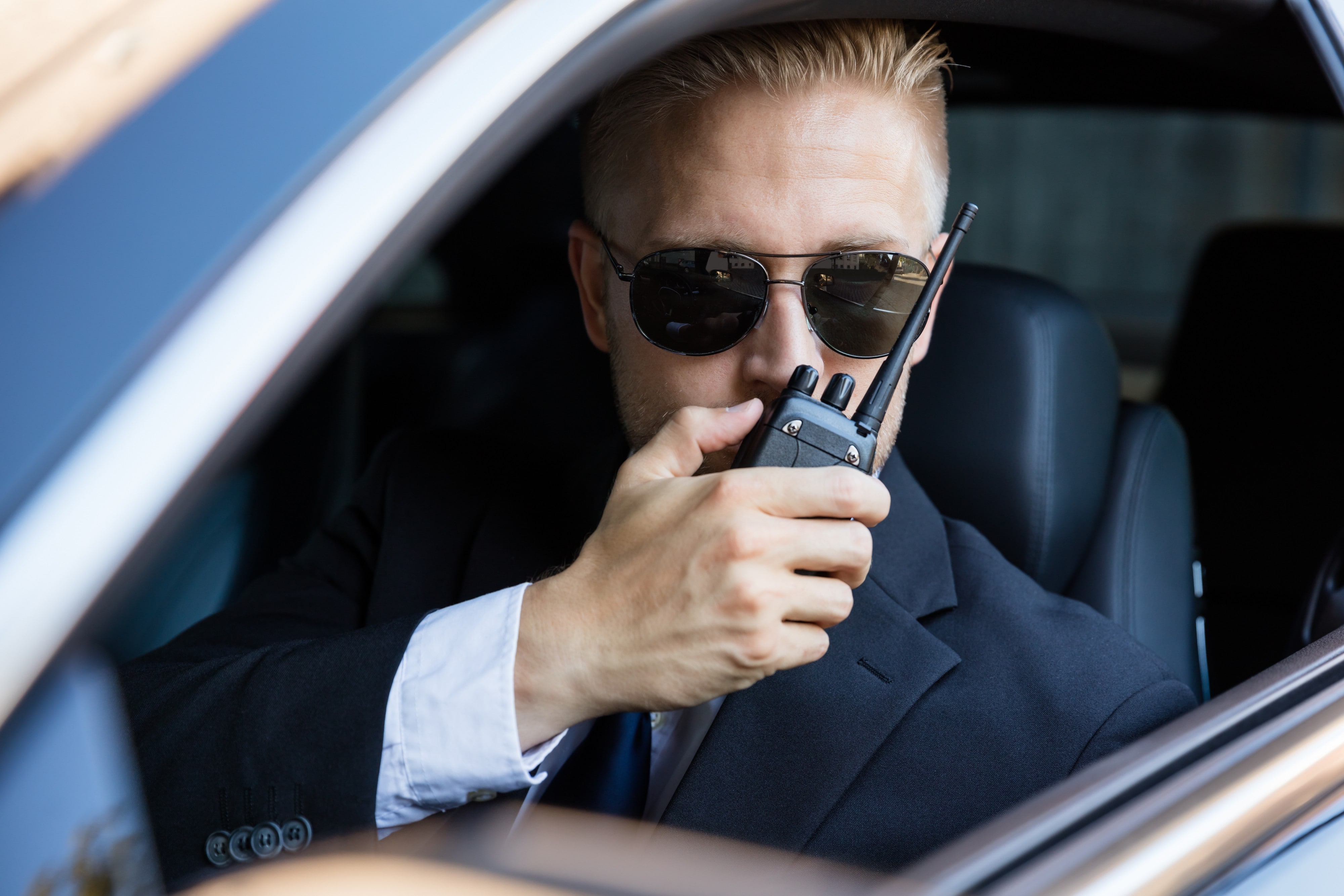 Man Sitting Inside Car Talking On Walkie Talkie